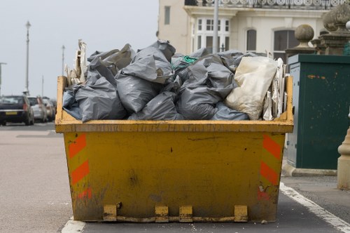 Workers inspecting a skip and reviewing safety documentation on site
